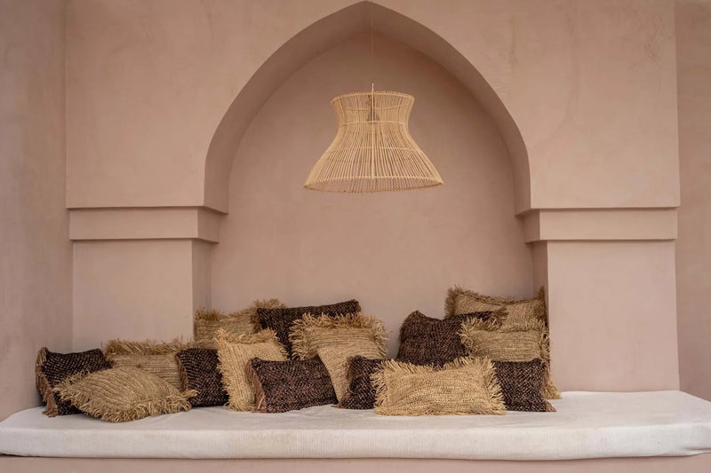 Coin déjeuner cocooning avec coussins en coton noir cuivre et luminaire en osier