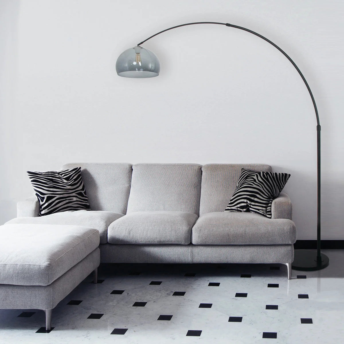 Canapé d’angle gris clair avec deux coussins en imprimé zèbre, style moderne