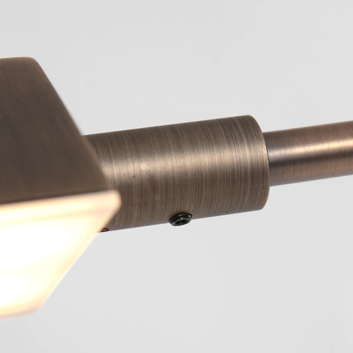 Applique métallique en bronze brossé avec ampoule visible et bras articulé orientable