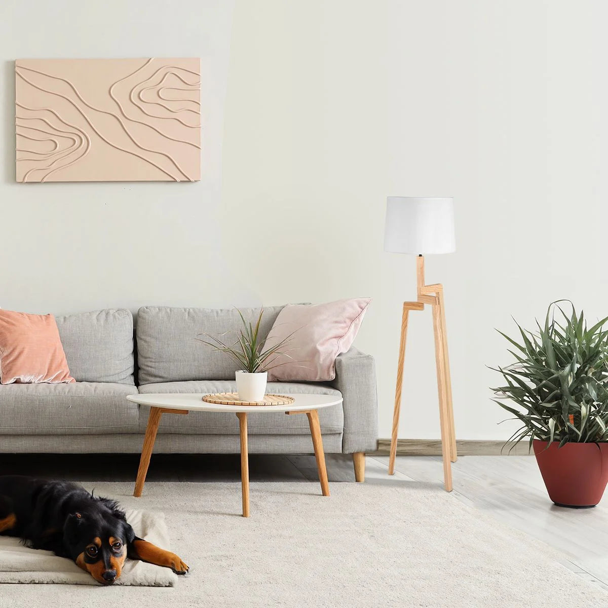 Canapé trois places gris clair avec deux coussins dans le salon moderne