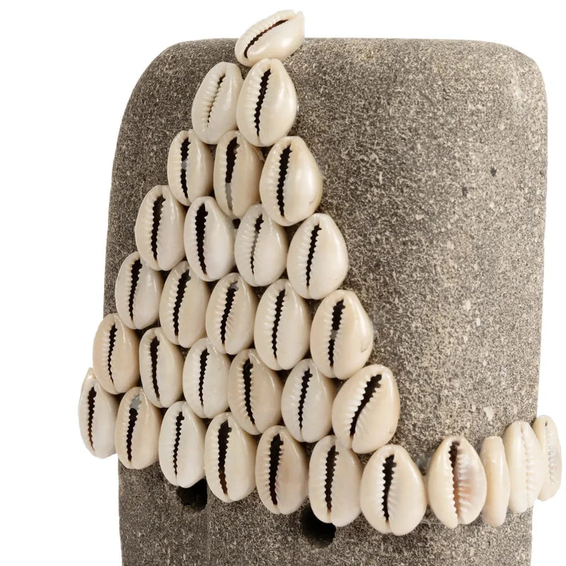Pierre grise ornementée de coquillages de cowrie sur support La Pierre de Sumba n°32