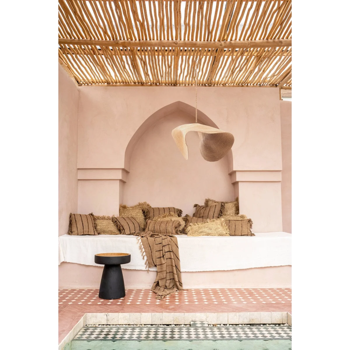 Espace de détente marocain avec coussins rayés et suspension en fibre tressée beige sable