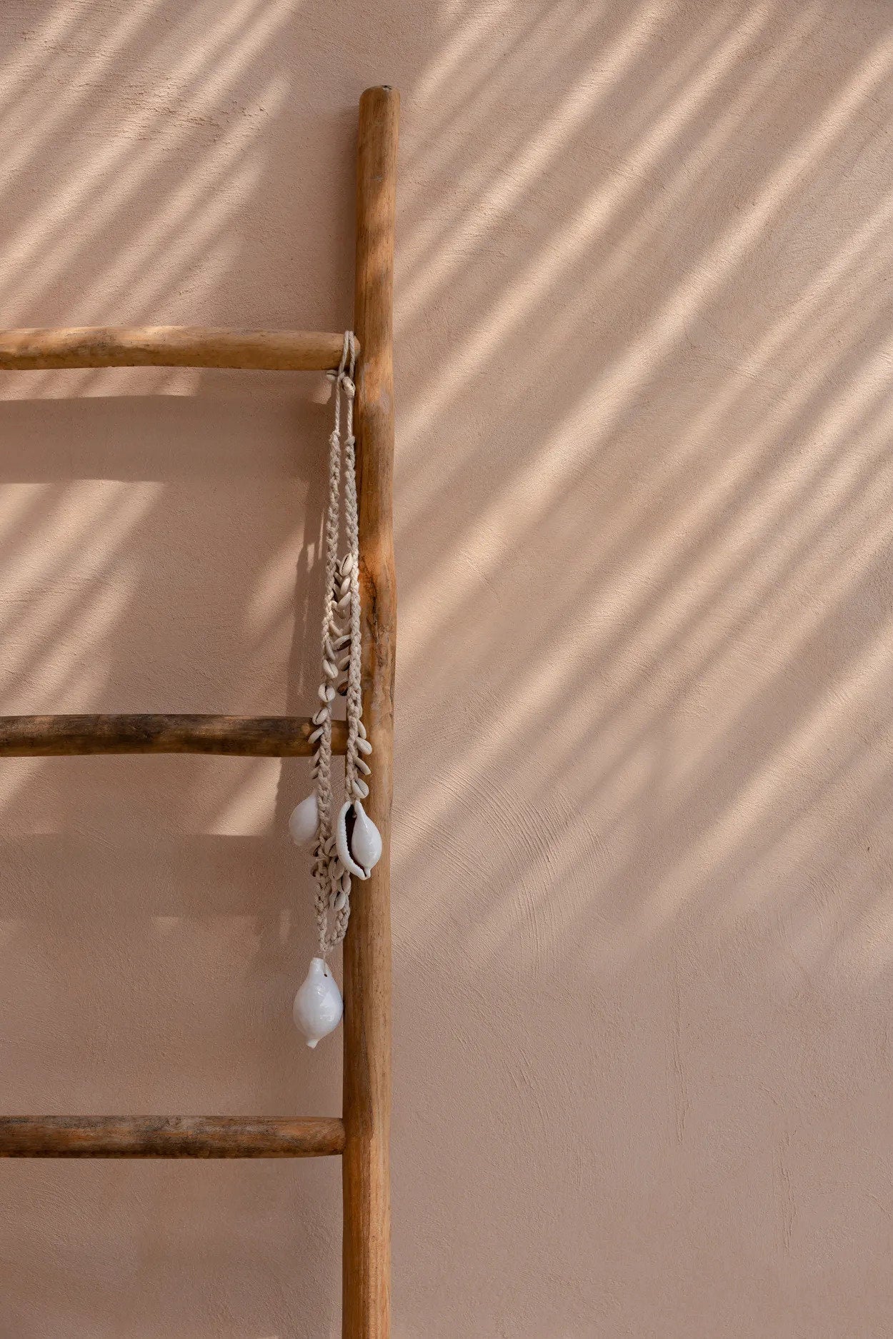 Collier décoratif coquillages cauris blancs en corde tressée suspendue