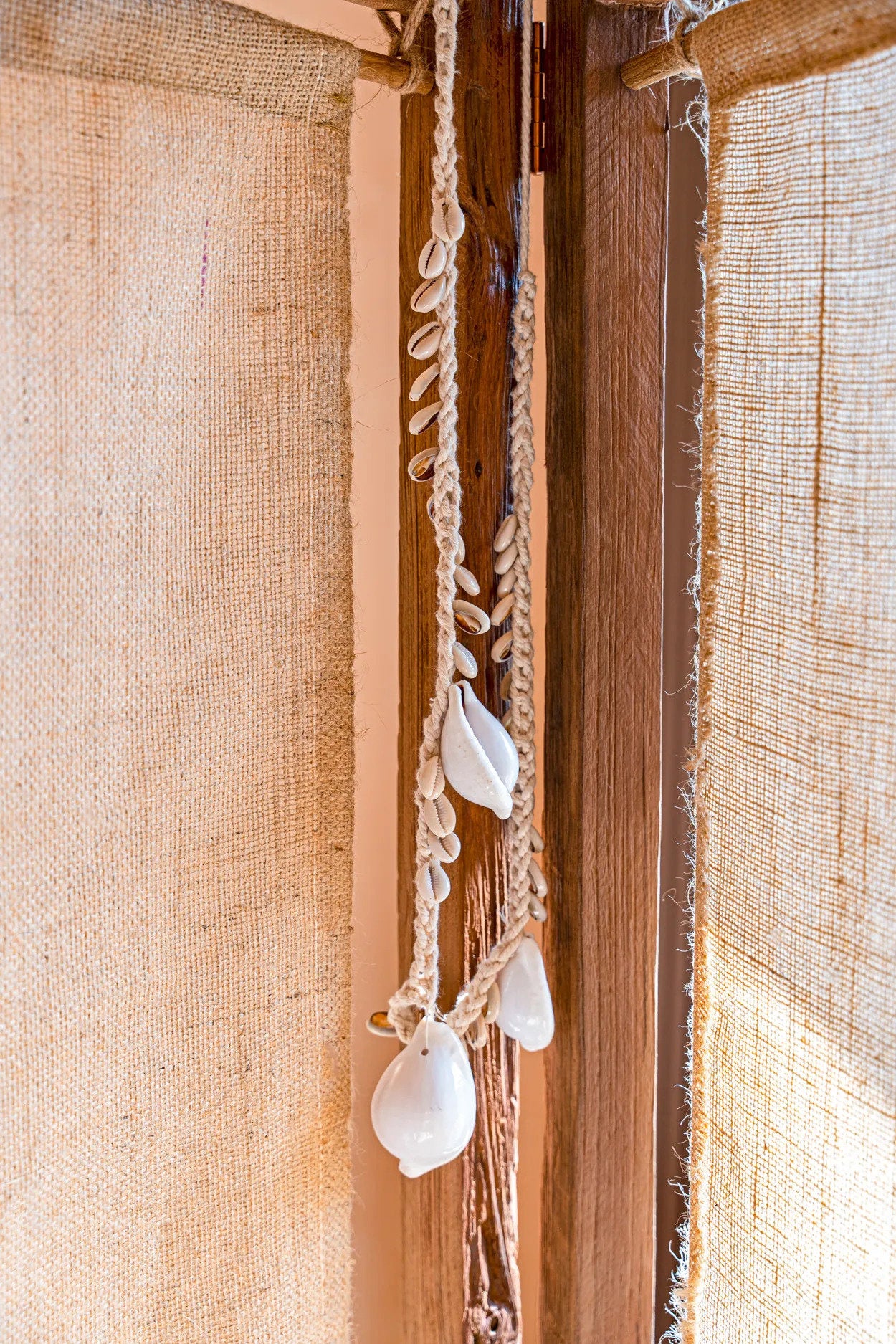 Collier décoratif coquillages cauris blancs en corde tressée suspendue