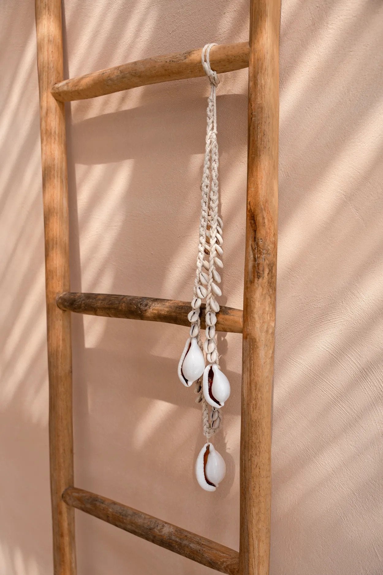 Collier décoratif coquillages cauris blancs en corde tressée suspendue