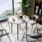 Table ronde effet marbre avec des chaises design dans une salle à manger chaleureuse.