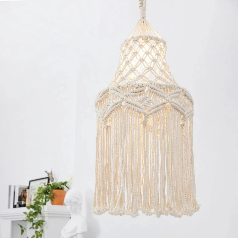 Abat-jour bohème tissé en coton diffusant une lumière douce dans une chambre.
