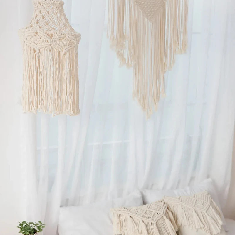 Suspension en macramé au-dessus d'un lit décoré, abat-jour bohème tissé en coton.
