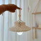 Abat-jour en macramé suspendu dans un salon, créant une ambiance chaleureuse et naturelle.