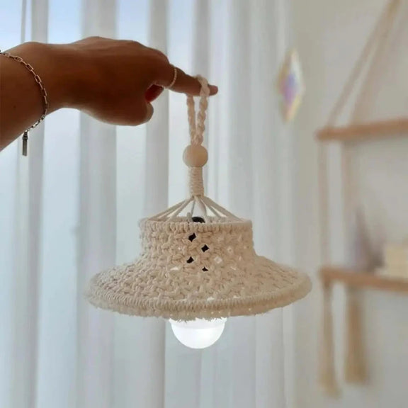 Abat-jour en macramé suspendu dans un salon, créant une ambiance chaleureuse et naturelle.