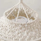 Zoom sur les détails du tissage en macramé d'un abat-jour bohème naturel.