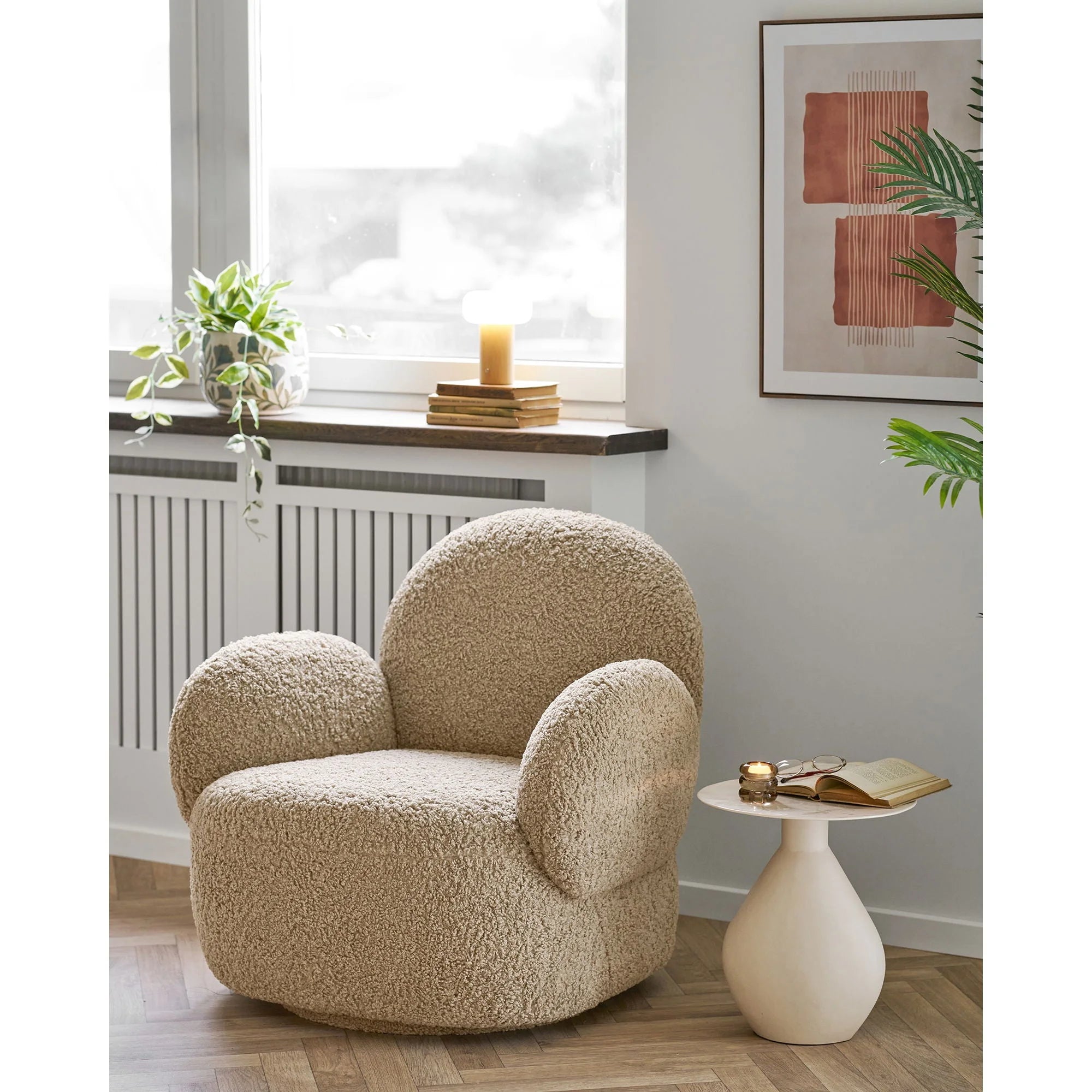Fauteuil beige moelleux arrondi en tissu texturé, affiche abstraite terracotta et beige encadrée bois 50x70 cm