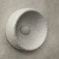 Gros plan sur la texture en résine de l'applique bohème chic, avec des reliefs travaillés.