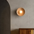 Applique murale ronde en bois fixée sur un mur gris, au design minimaliste et élégant