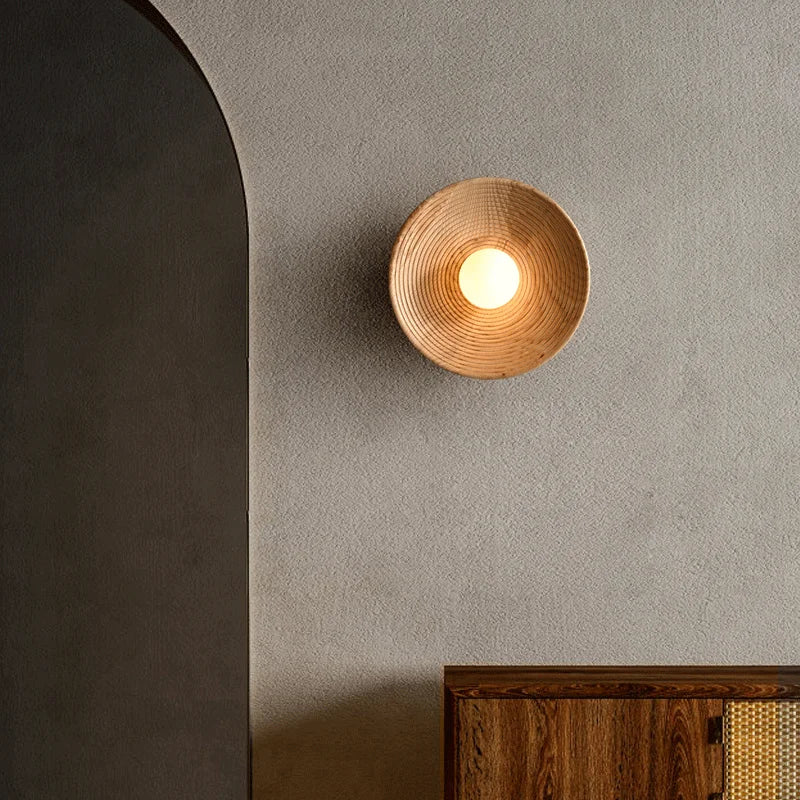 Applique murale ronde en bois fixée sur un mur gris, au design minimaliste et élégant