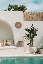 Espace lounge de style bohème au bord de la piscine avec applique murale en herbe et fer rond naturel