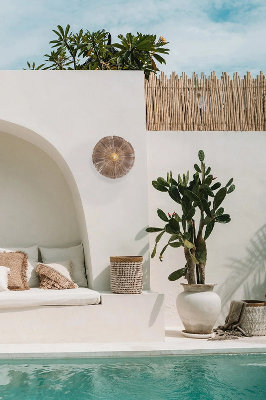 Espace lounge de style bohème au bord de la piscine avec applique murale en herbe et fer rond naturel
