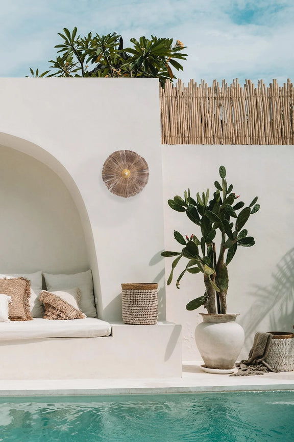 Espace lounge de style bohème au bord de la piscine avec applique murale en herbe et fer rond naturel