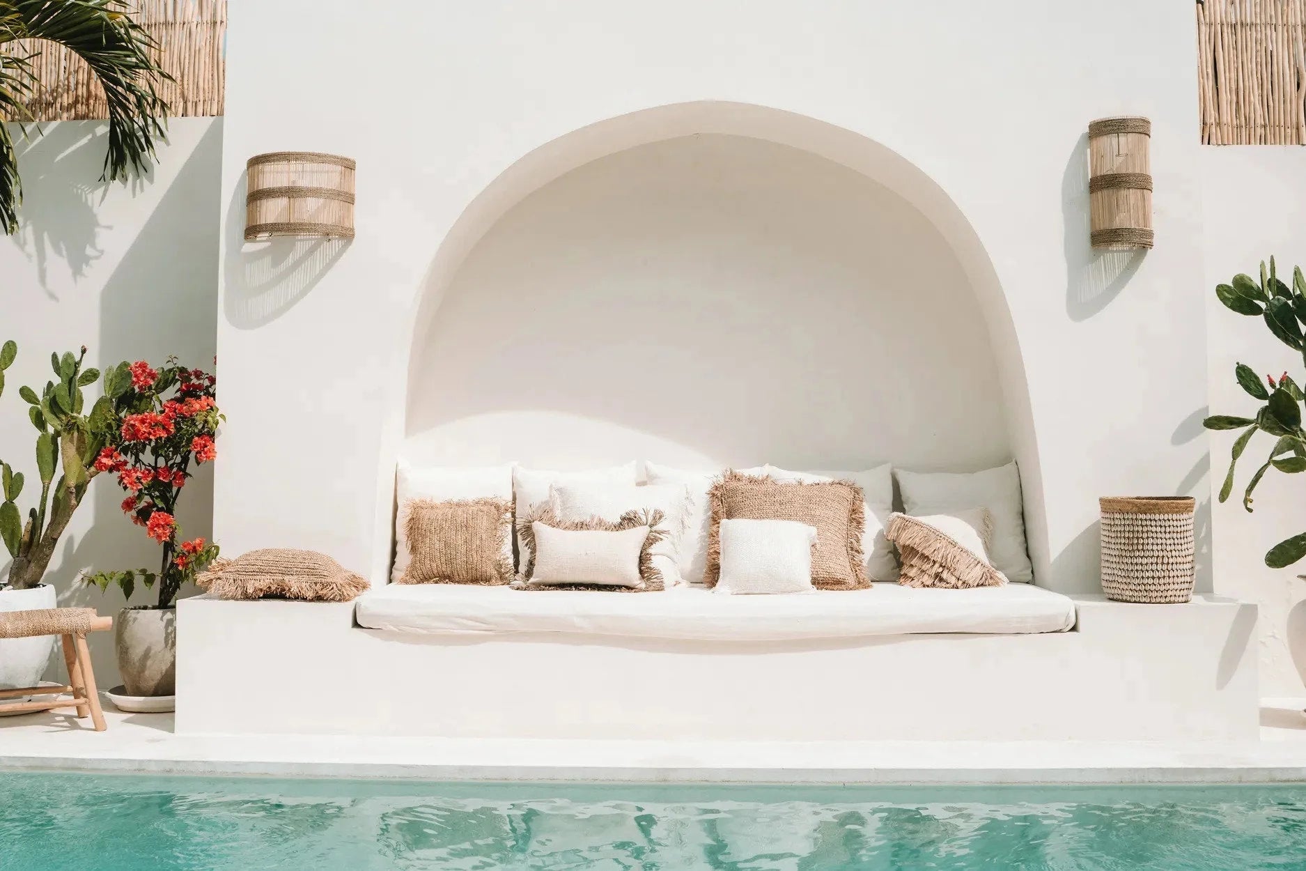Coin salon extérieur avec coussins en fibres naturelles et coussin blanc