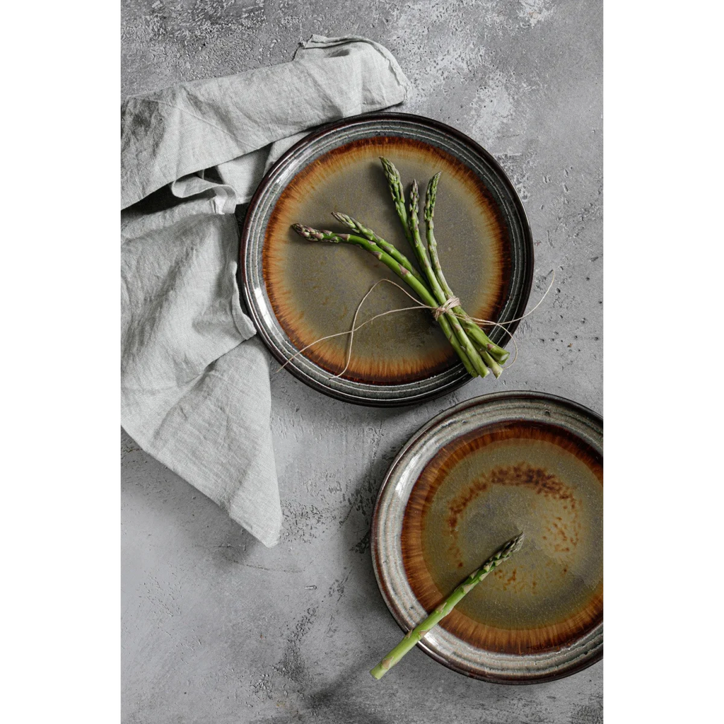 Asperges vertes fraîches liées avec de la ficelle sur une assiette en céramique artisanale