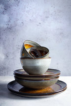 Pile d’assiettes en grès émaillé dégradé brun et gris moucheté artisanal rustique