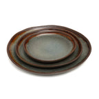 Ensemble de trois assiettes ovales en grès émaillé gris-vert à bord brun organique, mates et artisanales
