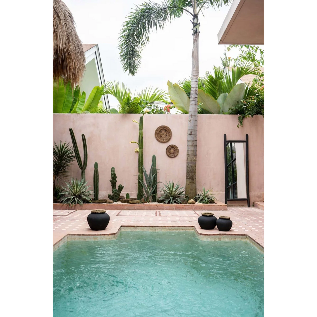 Piscine rectangulaire avec forme irrégulière, entourée de carreaux clairs et pots décoratifs