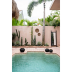 Piscine rectangulaire avec forme irrégulière, entourée de carreaux clairs et pots décoratifs