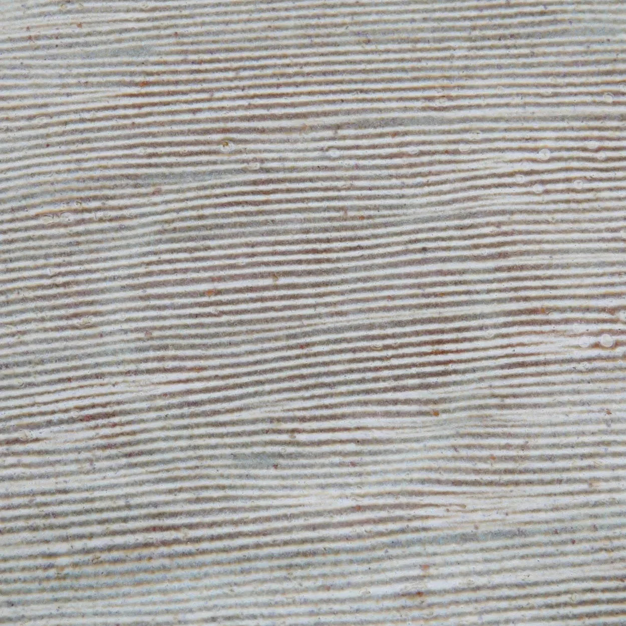 Assiette en grès artisanal gris clair à bord brun et motifs striés texturés