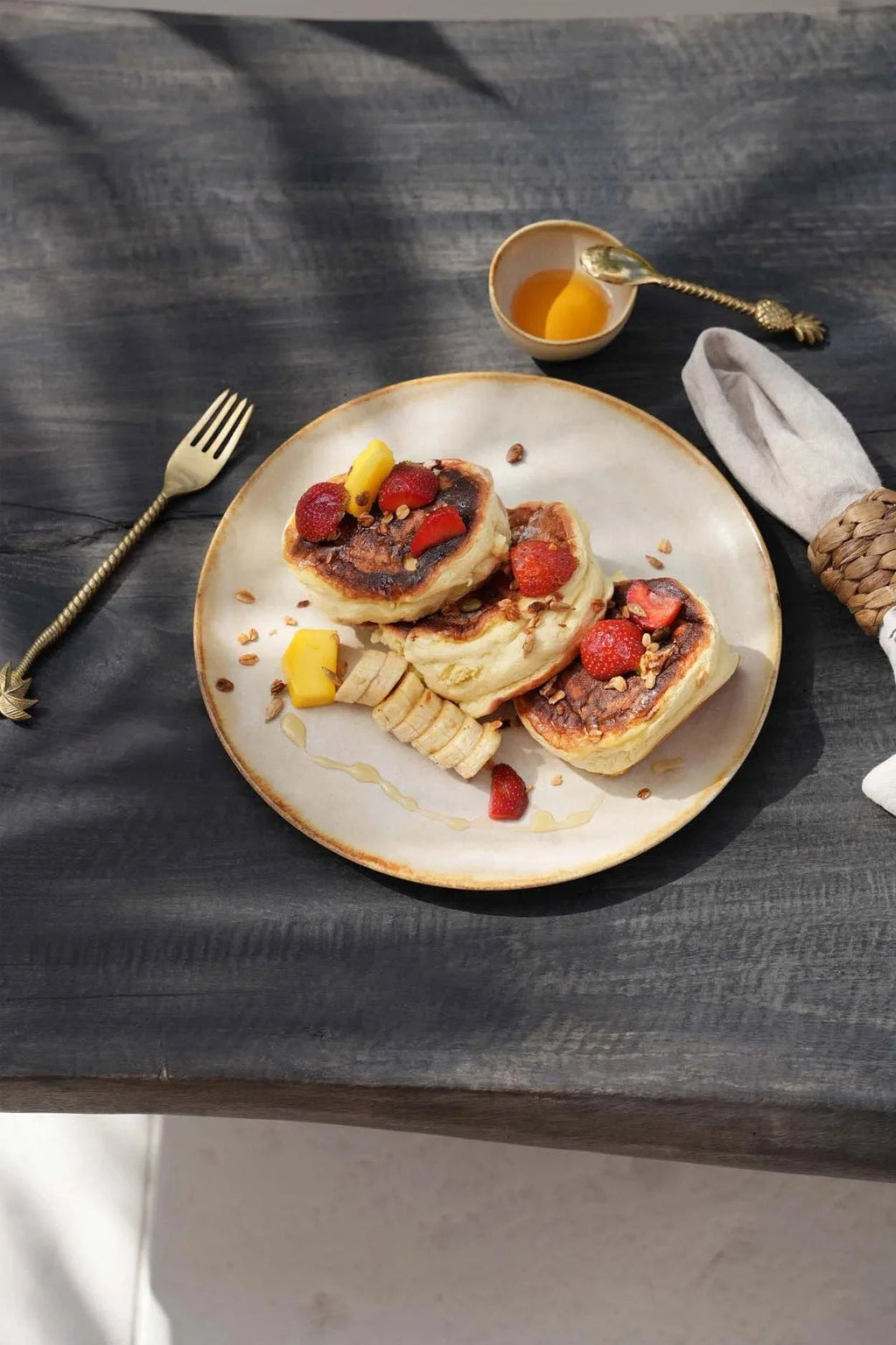Assiette en grès blanc cassé bord doré avec pancakes aux fraises et mangue