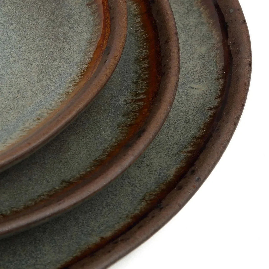 Assiette en grès émaillé gris-vert à bord irrégulier, patine gris-brun