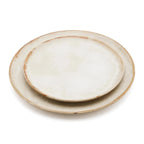 Deux assiettes en grès empilées, ivoire moucheté mat, bord brun artisanal distressed