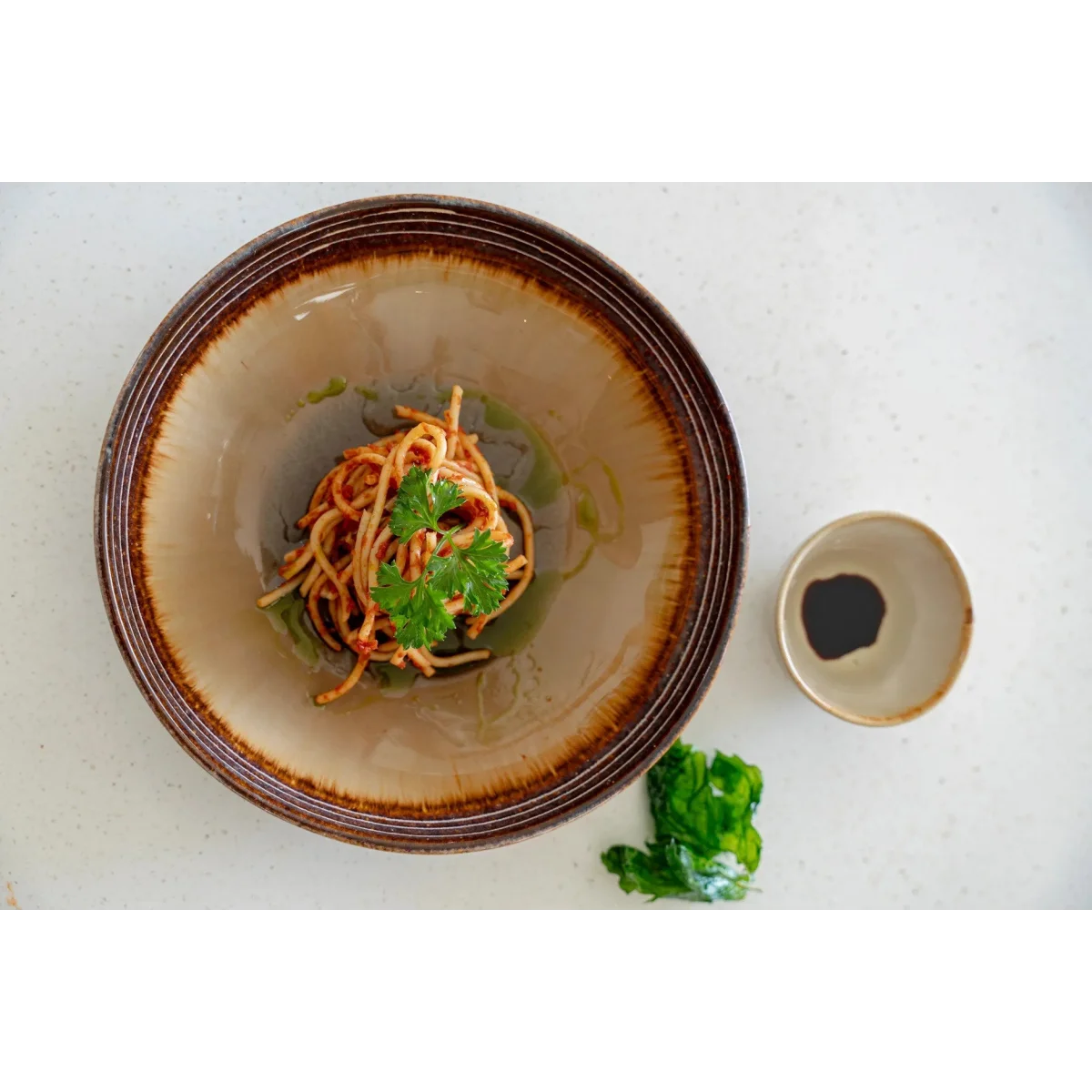 Assiette à pâtes en céramique émaillée gris brun avec pâtes sauce tomate et légumes
