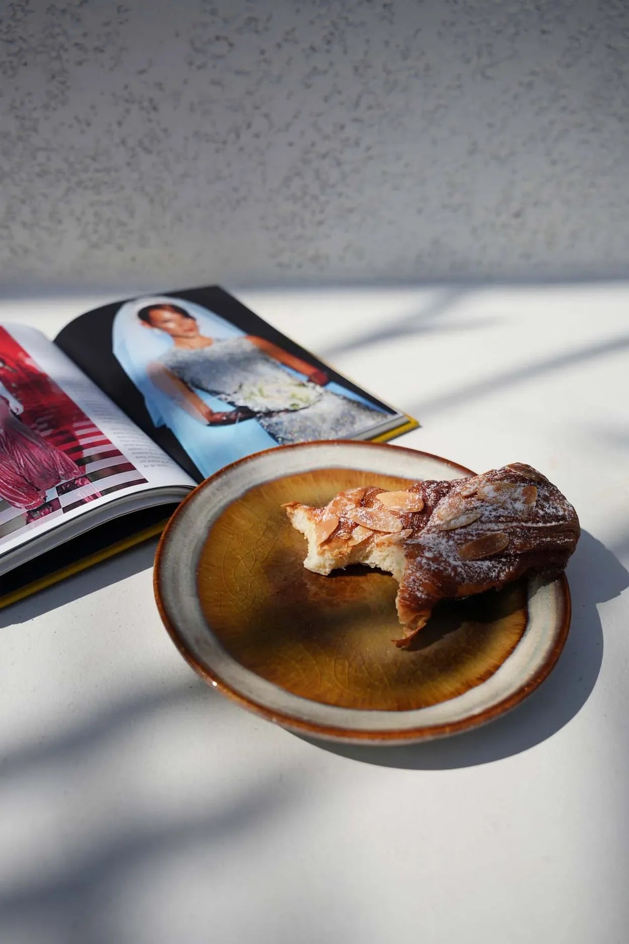 Partagez un moment gourmand avec une pâtisserie partiellement mangée sur une assiette en céramique dégradée beige et marron