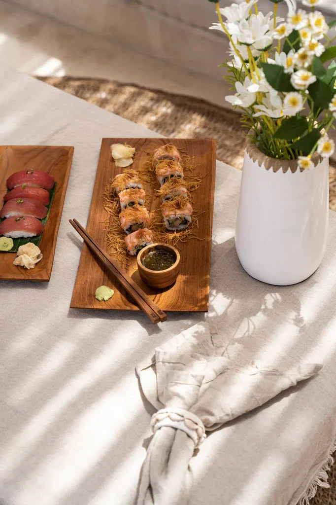 Arrangement de sushi avec des fleurs pour Les Baguettes en Racine de Teck