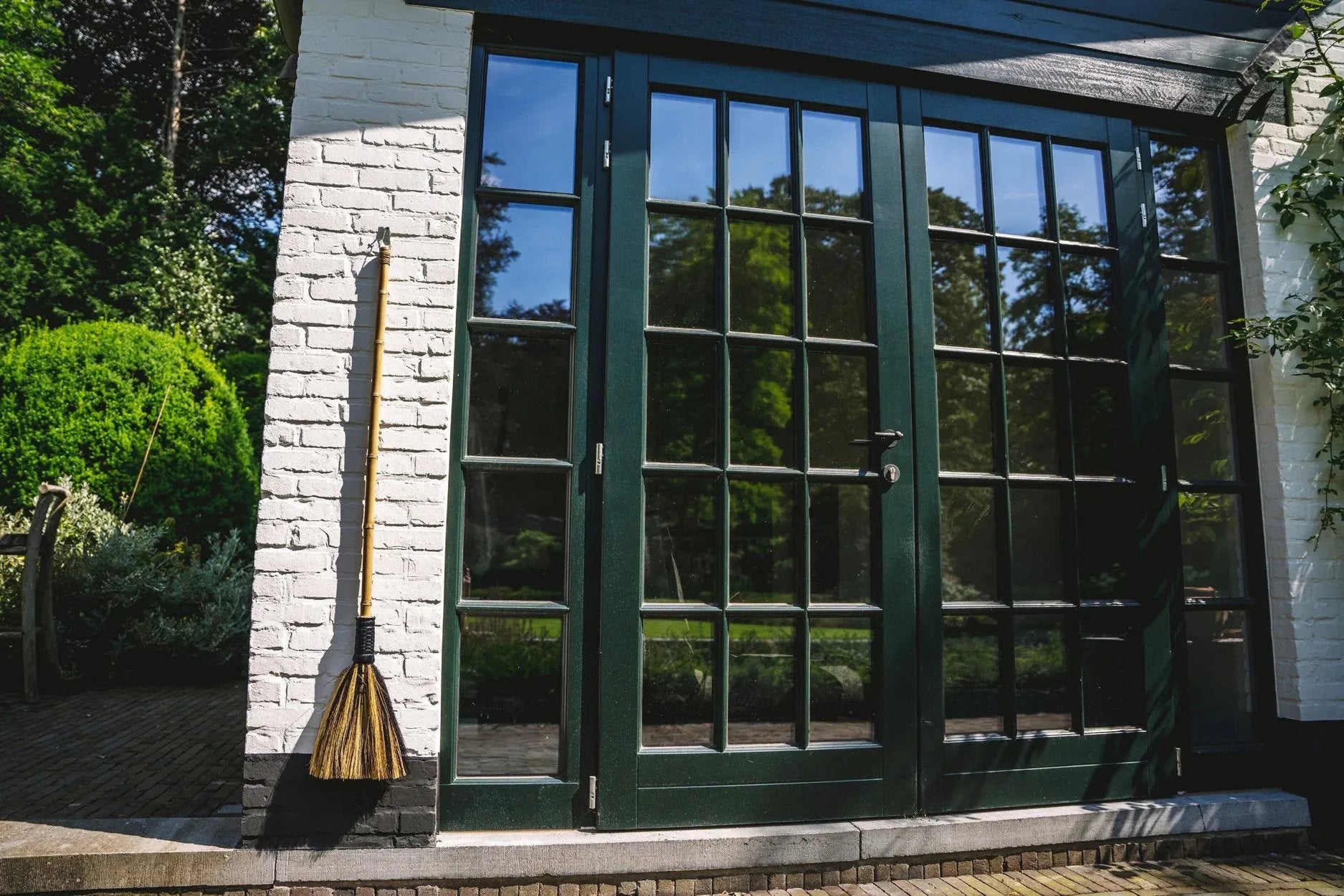 Porte en verre encadrée de vert avec cadre en fibres naturelles beige et noir
