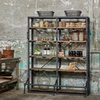 Bibliothèque double en métal noir et bois naturel sur fond de murs béton rustiques