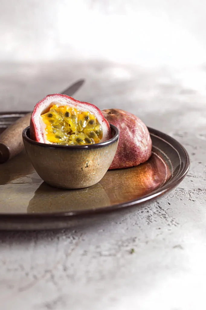 Haalves de fruit de la passion sur une assiette avec le bol à sauce Comporta XS
