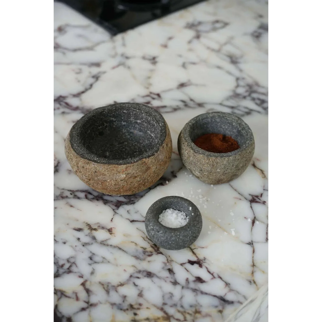 Mortier et pilon en pierre de lave grise granité avec épices rouges