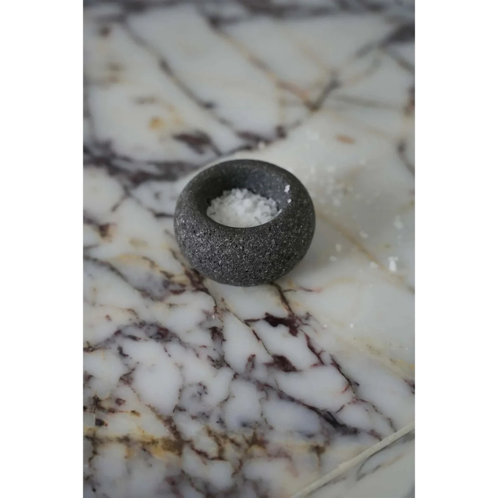 Bol à sel en pierre de lave gris granité forme galet sur marbre