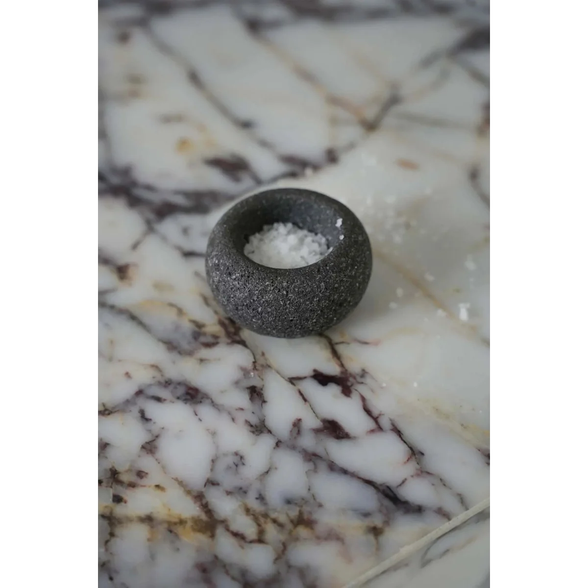 Bol à sel en pierre de lave gris granité forme galet sur marbre