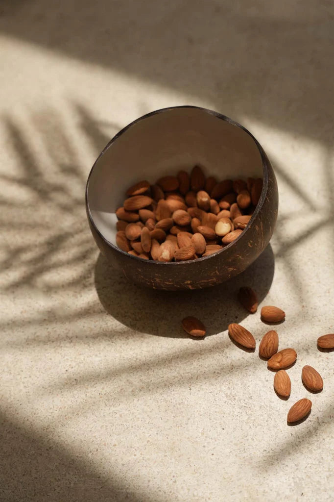 Amandes dans un bol en forme de coquille de noix de coco.