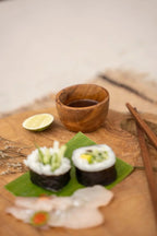 Sushi avec légumes frais, bol en teck pour sel ou épices, sauce soja et citron vert