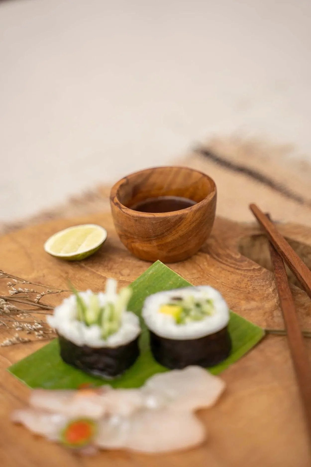 Plateau de sushi avec sauce soja sur bol en bois de teck naturel rond pour sel ou épices