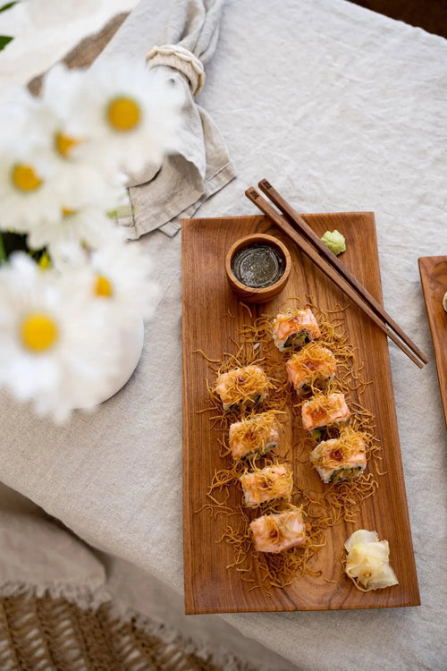 Sushi rolls avec toppings croustillants sur un plateau en bois de teck naturel
