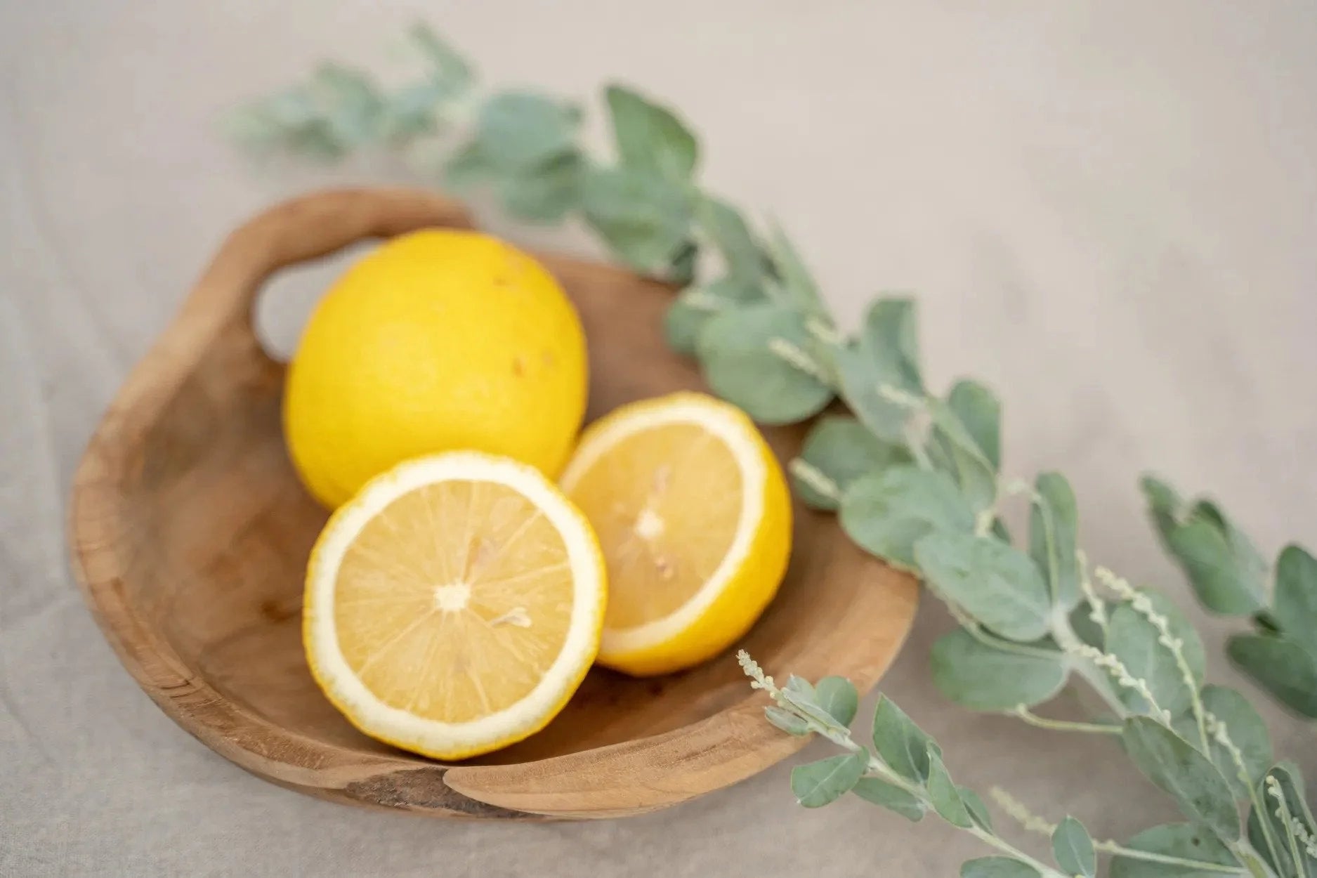 Lemons fraîches sur une assiette en bois de teck avec poignée intégrée naturelle