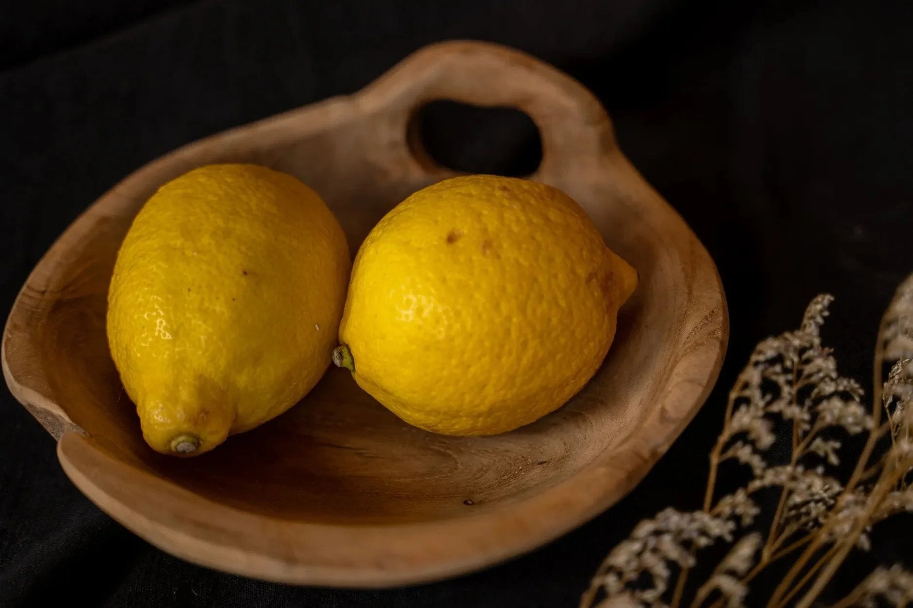 Citron jaune dans un bol en bois de teck avec poignée intégrée finition naturelle