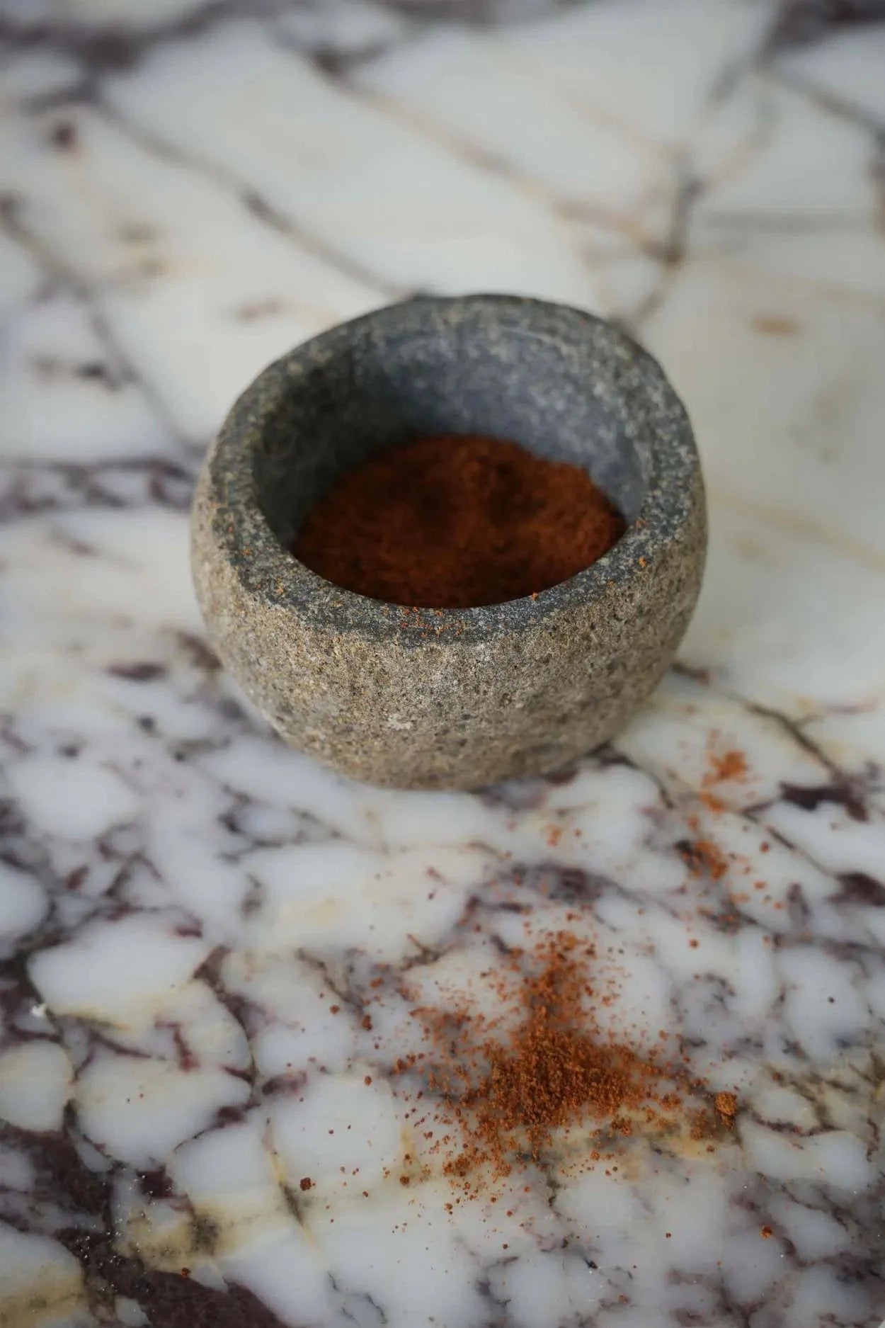 Mortier en pierre avec poudre brun rouge pour bol décoratif en pierre aspect brut