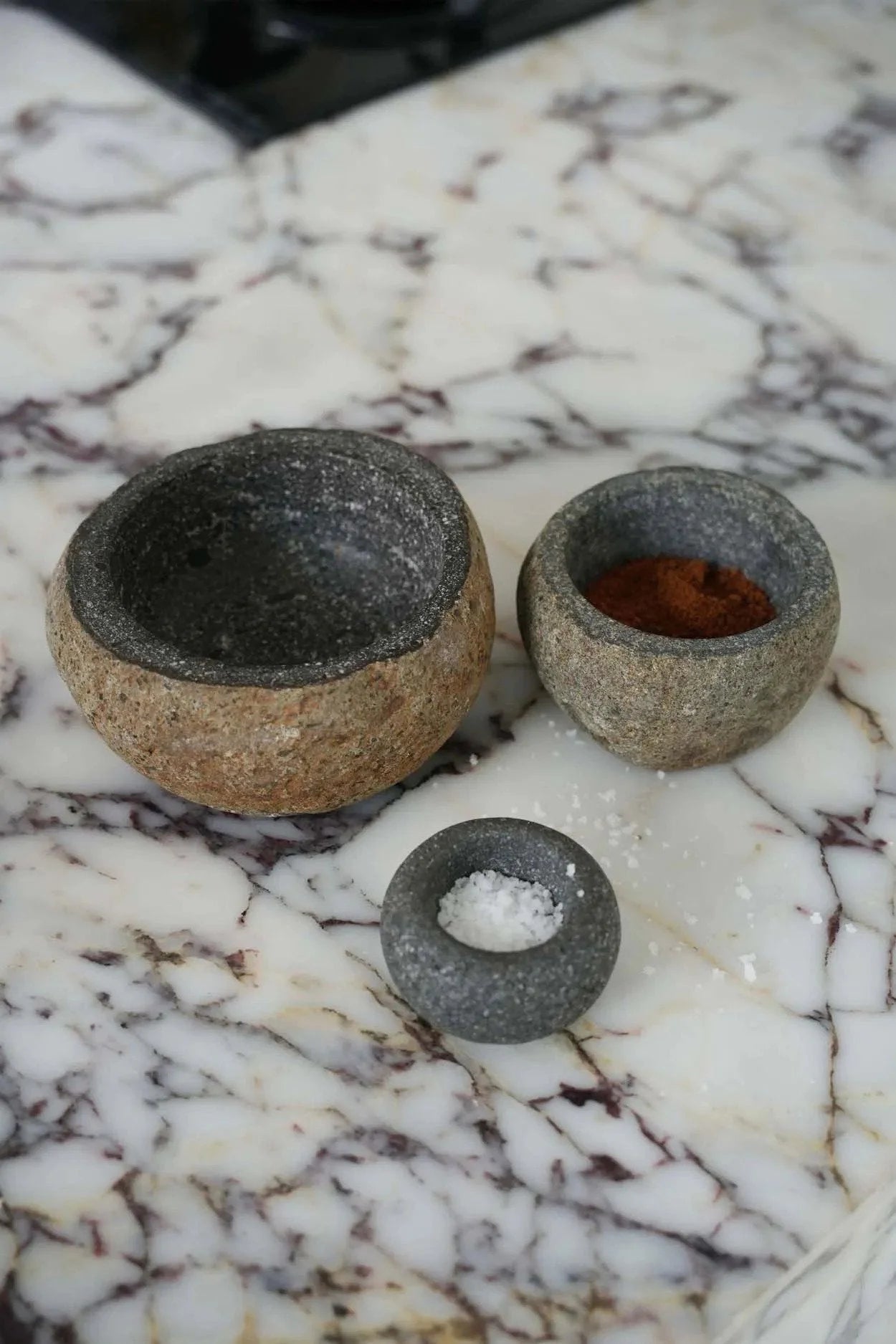 Trois bols en pierre aspect brut avec épices pour décoration intérieure élégante