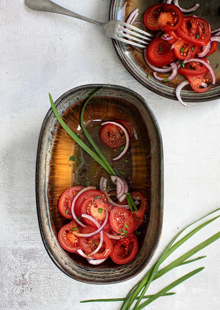 Salade de tomates et oignons dans le bol ovale Comporta L ensemble de 4